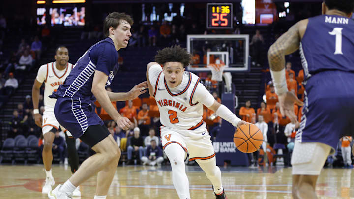 Nov 28, 2025; Charlottesville, Virginia, USA; Virginia Cavaliers guard Chance Mallory (2) dribbles the ball as Queens University of Charlotte Royals forward Carson Schwieger (22) defends during the second half at John Paul Jones Arena. Mandatory Credit: Amber Searls-Imagn Images