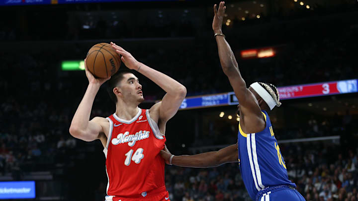 Apr 1, 2025; Memphis, Tennessee, USA; Memphis Grizzlies center Zach Edey (14) shoots as Golden State Warriors forward Jimmy Butler III (10) defends during the first quarter at FedExForum.
