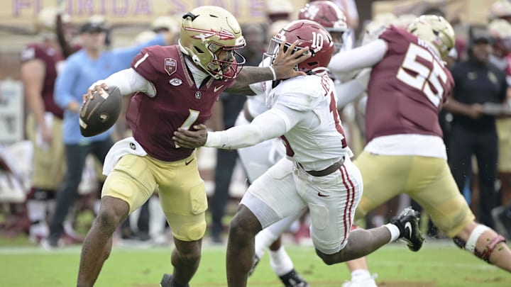  Florida State Seminoles quarterback Tommy Castellanos (1) stiff arms Alabama Crimson Tide linebacker Justin Jefferson (1