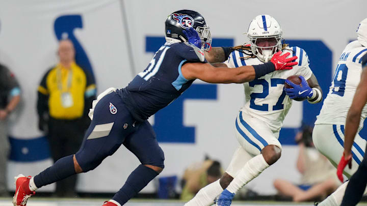 Tennessee Titans linebacker Cedric Gray (51) reaches for Indianapolis Colts running back Trey Sermon (27) on Sunday, Dec. 22, 2024, during a game against the Tennessee Titans at Lucas Oil Stadium in Indianapolis.
