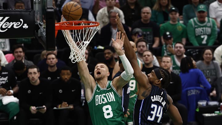 Apr 23, 2025; Boston, Massachusetts, USA; Boston Celtics center Kristaps Porzingis (8) goes to the basket past Orlando Magic center Wendell Carter Jr. (34) during the first quarter of game two of the first round of the 2024 NBA Playoffs at TD Garden. Mandatory Credit: Winslow Townson-Imagn Images