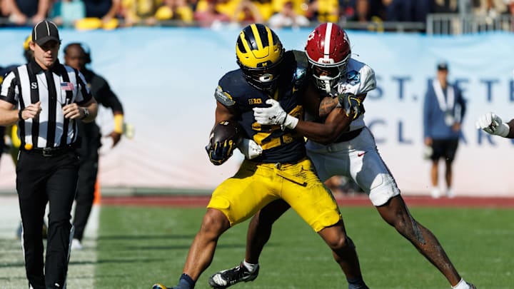 Dec 31, 2024; Tampa, FL, USA; Alabama Crimson Tide defensive back Zavier Mincey (12) tackles Michigan Wolverines running back Jordan Marshall (23) during the second half at Raymond James Stadium. Mandatory Credit: Matt Pendleton-Imagn Images