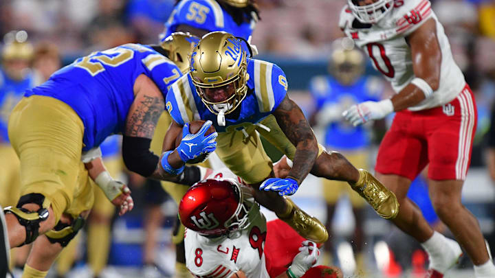 Aug 30, 2025; Pasadena, California, USA; UCLA Bruins quarterback Nico Iamaleava (9) moves the ball against Utah Utes linebacker Lander Barton (8) during the first half at Rose Bowl. Mandatory Credit: Gary A. Vasquez-Imagn Images