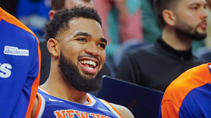 Dec 19, 2024; Minneapolis, Minnesota, USA; New York Knicks forward Karl-Anthony Towns (32) smiles as he rests on the bench in the fourth quarter of the game with the Minnesota Timberwolves at Target Center. Mandatory Credit: Bruce Kluckhohn-Imagn Images