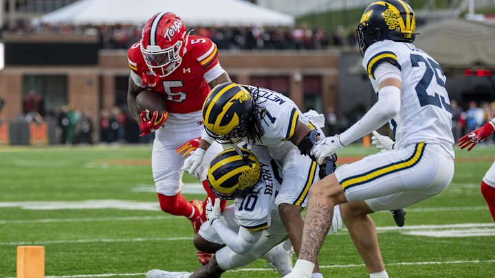 Nov 22, 2025; College Park, Maryland, USA;  Michigan Wolverines defensive back TJ Metcalf (7) and defensive back Zeke Berry (10) tackle Maryland Terrapins wide receiver Octavian Smith Jr. (5) during the first quarter at SECU Stadium. Mandatory Credit: Tommy Gilligan-Imagn Images