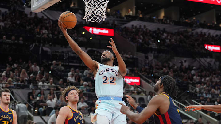 Mar 30, 2025; San Antonio, Texas, USA;  San Antonio Spurs guard Malaki Branham (22) shoots in front of Golden State Warriors guards Brandin Podziemski (2) and Buddy Hield (7) in the second half at Frost Bank Center. Mandatory Credit: Daniel Dunn-Imagn Images