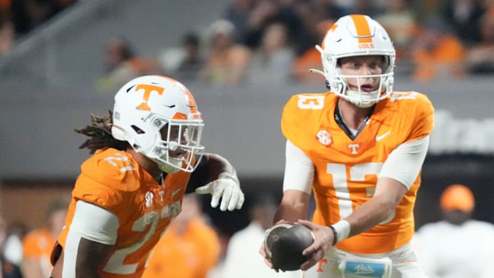 Tennessee Volunteers quarterback Gaston Moore (13) hands off to running back Peyton Lewis (27) against the Mississippi State Bulldogs Tennessee Volunteers quarterback Gaston Moore (13) hands off to running back Peyton Lewis (27) against the Mississippi State Bulldogs
