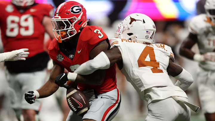 Dec 7, 2024; Atlanta, GA, USA; Georgia Bulldogs running back Nate Frazier (3) fumbles the ball against Texas Longhorns defensive back Andrew Mukuba (4) during the second half in the 2024 SEC Championship game at Mercedes-Benz Stadium. 