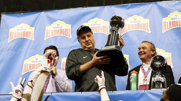 Dec 28, 2018; San Antonio, TX, United States; Washington State Cougars head coach Mike Leach holds up the Champions trophy after the Valero Alamo Bowl game between the Iowa State Cyclones and the Washington State Cougars at Alamodome. Mandatory Credit: Soobum Im-Imagn Images