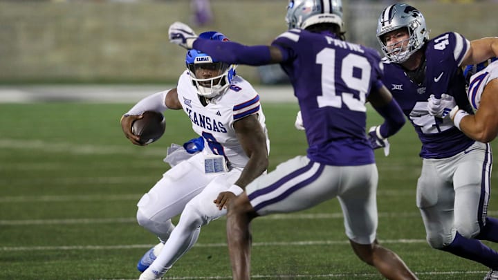 Oct 26, 2024; Manhattan, Kansas, USA; Kansas Jayhawks quarterback Jalon Daniels (6) looks for room to run against Kansas State Wildcats safety VJ Payne (19) during the second quarter at Bill Snyder Family Football Stadium. Mandatory Credit: Scott Sewell-Imagn Images