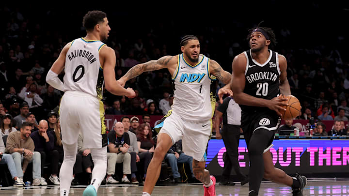 Jan 6, 2025; Brooklyn, New York, USA; Brooklyn Nets center Day'Ron Sharpe (20) drives to the basket against Indiana Pacers forward Obi Toppin (1) and guard Tyrese Haliburton (0) during the fourth quarter at Barclays Center. Mandatory Credit: Brad Penner-Imagn Images