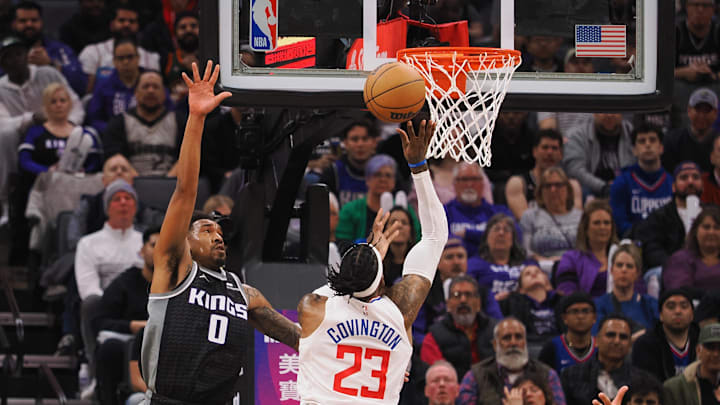 Mar 3, 2023; Sacramento, California, USA; Los Angeles Clippers power forward Robert Covington (23) scores a layup against Sacramento Kings shooting guard Malik Monk (0) during the second quarter at Golden 1 Center. Mandatory Credit: Kelley L Cox-USA TODAY Sports