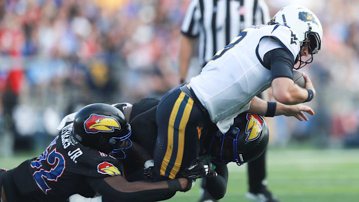 Kansas Jayhawks defensive tackle D.J. Withers (52) brings down West Virginia Mountaineers quarterback Nicco Marchiol (8) during the first half of the game against West Virginia Mountaineers at David Booth Kansas Memorial Stadium on Sept. 20, 2025. Kansas Jayhawks defensive tackle D.J. Withers (52) brings down West Virginia Mountaineers quarterback Nicco Marchiol (8) during the first half of the game against West Virginia Mountaineers at David Booth Kansas Memorial Stadium on Sept. 20, 2025.