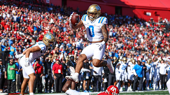 Oct 19, 2024; Piscataway, New Jersey, USA;  UCLA Bruins running back Jalen Berger (0) scores on a touchdown reception as Rutgers Scarlet Knights defensive back Robert Longerbeam (7) defends during the second half at SHI Stadium. Mandatory Credit: Vincent Carchietta-Imagn Images