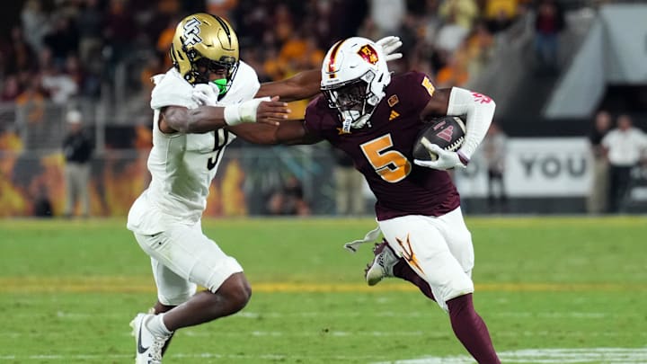 Nov 9, 2024; Tempe, Arizona, USA; Arizona State Sun Devils wide receiver Melquan Stovall (5) delivers a stiff arm to UCF Knights defensive back Sheldon Arnold (9) during the second half at Mountain America Stadium, Home of the ASU Sun Devils. Mandatory Credit: Joe Camporeale-Imagn Images