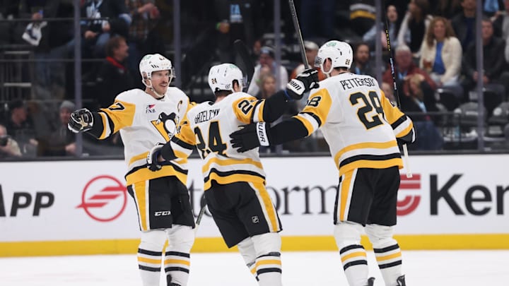 Jan 29, 2025; Salt Lake City, Utah, USA; Pittsburgh Penguins defenseman Marcus Pettersson (28) celebrates scoring a goal with defenseman Matt Grzelcyk (24) and center Sidney Crosby (87) during the second period at Delta Center. Mandatory Credit: Rob Gray-Imagn Images