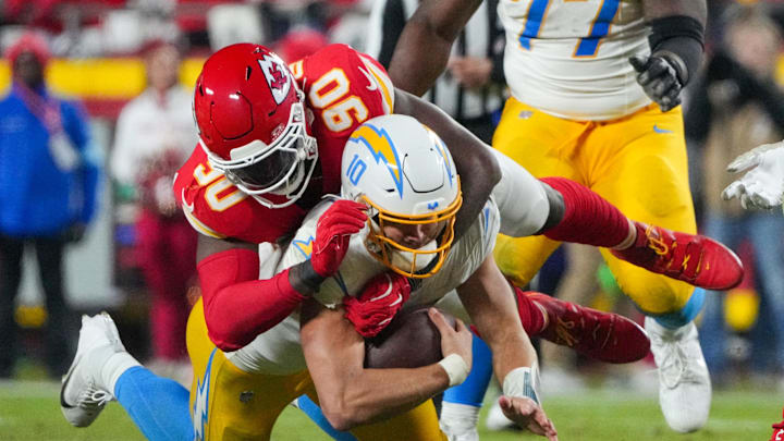 Dec 8, 2024; Kansas City, Missouri, USA; Los Angeles Chargers quarterback Justin Herbert (10) is sacked by Kansas City Chiefs defensive end Charles Omenihu (90) during the second half at GEHA Field at Arrowhead Stadium. Mandatory Credit: Denny Medley-Imagn Images