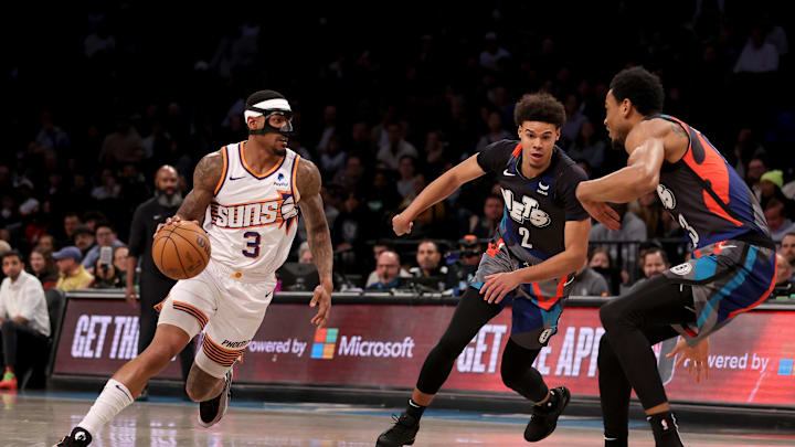 Jan 31, 2024; Brooklyn, New York, USA; Phoenix Suns guard Bradley Beal (3) controls the ball against Brooklyn Nets forward Cameron Johnson (2) and center Nic Claxton (33) during the first quarter at Barclays Center. Mandatory Credit: Brad Penner-Imagn Images