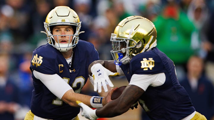 Notre Dame quarterback Riley Leonard (13) hands the ball off to running back Jeremiyah Love (4) during a NCAA college football game against Virginia at Notre Dame Stadium on Saturday, Nov. 16, 2024, in South Bend.
