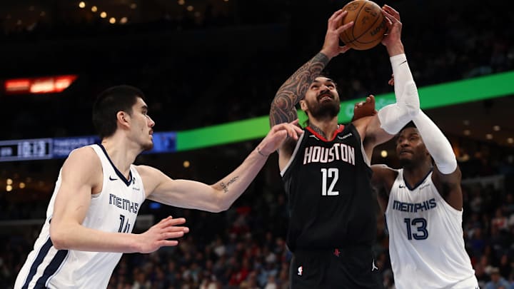 Jan 9, 2025; Memphis, Tennessee, USA; Houston Rockets center Steven Adams (12) shoots between Memphis Grizzlies center Zach Edey (14) and Memphis Grizzlies forward Jaren Jackson Jr. (13) during the fourth quarter at FedExForum. Mandatory Credit: Petre Thomas-Imagn Images