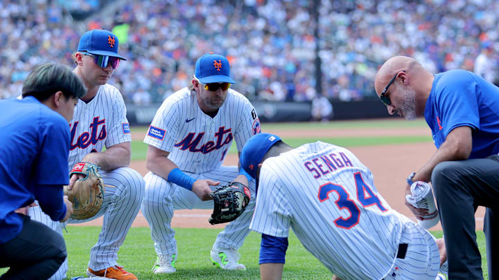 Jun 12, 2025; New York City, New York, USA; New York Mets first baseman Pete Alonso (20) and second baseman Jeff McNeil (1) watch as starting pitcher Kodai Senga (34) is tended to after sustaining an injury during the sixth inning against the Washington Nationals at Citi Field. Mandatory Credit: Brad Penner-Imagn Images