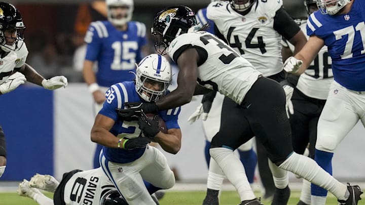 Jan 5, 2025; Indianapolis, Indiana, USA; Indianapolis Colts running back Jonathan Taylor (28) is brought down by Jacksonville Jaguars safety Darnell Savage (6) and Jacksonville Jaguars linebacker Devin Lloyd (33) during a game against the Jacksonville Jaguars at Lucas Oil Stadium. Mandatory Credit: Christine Tannous/USA TODAY Network via Imagn Images