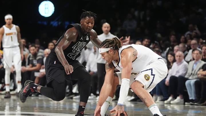 Oct 29, 2024; Brooklyn, New York, USA; Denver Nuggets power forward Aaron Gordon (32) grabs a loose ball against Brooklyn Nets power forward Dorian Finney-Smith (28) during the second half at Barclays Center. Mandatory Credit: Gregory Fisher-Imagn Images