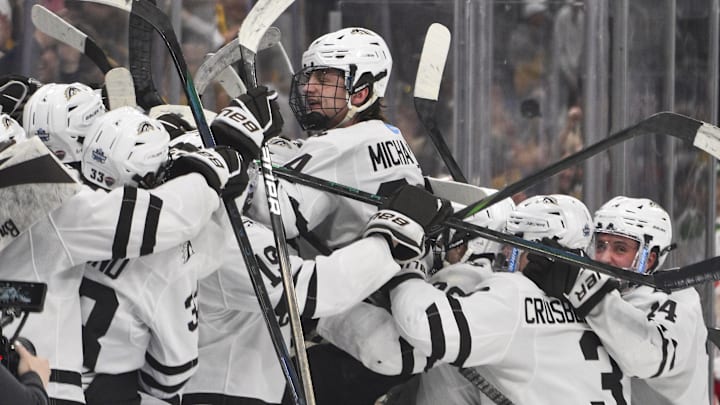 Apr 12, 2025; St. Louis, Missouri, UNITED STATES; Western Michigan Broncos forward Owen Michaels (34) leaps in to his bench and celebrates with teammates after scoring an empty net goal against the Boston University Terriers during the third period of the Frozen Four college ice hockey national championship at Enterprise Center. 