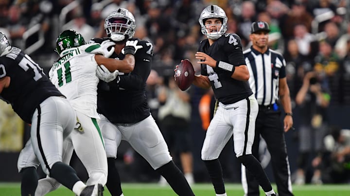 Nov 12, 2023; Paradise, Nevada, USA; Las Vegas Raiders quarterback Aidan O'Connell (4) drops back to pass as offensive tackle Thayer Munford Jr. (77) provides coverage against New York Jets linebacker Jermaine Johnson (11) during the first half at Allegiant Stadium. Mandatory Credit: Gary A. Vasquez-USA TODAY Sports
