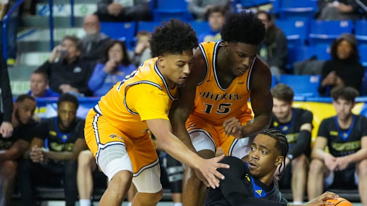 Delaware's Niels Lane gets rid of the ball against Drexel's Jason Drake (left) and Cole Hargrove in the second half of Delaware's 78-74 loss at the Bob Carpenter Center, Thursday, Feb. 20, 2025.