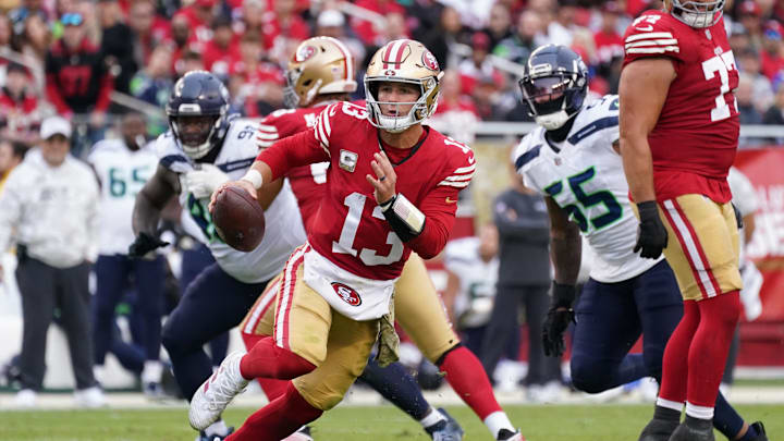 Nov 17, 2024; Santa Clara, California, USA; San Francisco 49ers quarterback Brock Purdy (13) scrambles away from Seattle Seahawks offensive tackle Michael Jerrell (65) in the third quarter at Levi's Stadium. Mandatory Credit: David Gonzales-Imagn Images