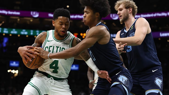Nov 12, 2025; Boston, Massachusetts, USA; Memphis Grizzlies forward Jaylen Wells (0) reaches in on Boston Celtics guard Anfernee Simons (4) during the second half at TD Garden. Mandatory Credit: Winslow Townson-Imagn Images