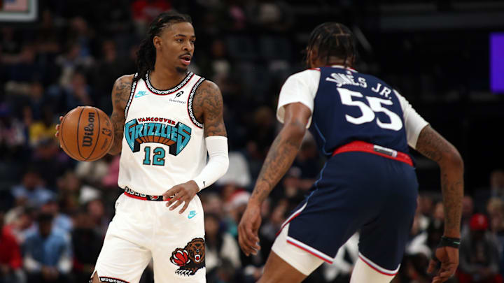 Dec 23, 2024; Memphis, Tennessee, USA; Memphis Grizzlies guard Ja Morant (12) dribbles as Los Angeles Clippers forward Derrick Jones Jr. (55) defends during the first quarter at FedExForum. Mandatory Credit: Petre Thomas-Imagn Images