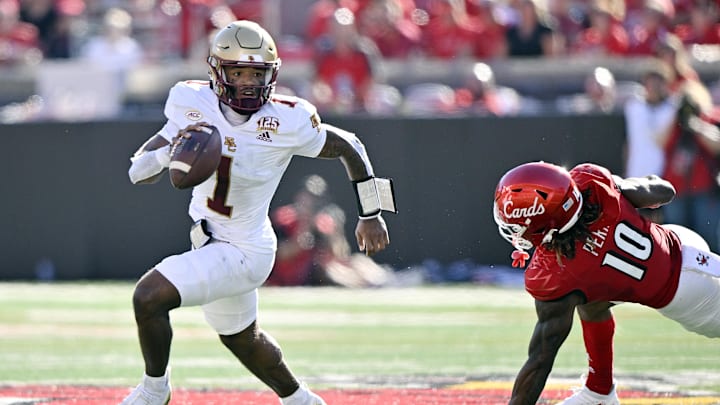 Sep 23, 2023; Louisville, Kentucky, USA;  Boston College Eagles quarterback Thomas Castellanos (1) scrambles with the ball against Louisville Cardinals defensive back Benjamin Perry (10) during the first half at L&N Federal Credit Union Stadium. Mandatory Credit: Jamie Rhodes-Imagn Images