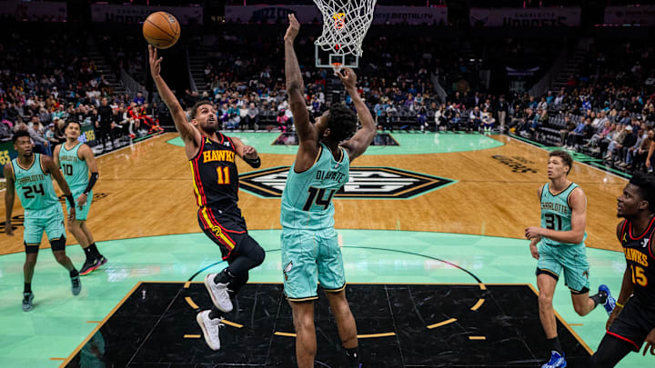 Nov 30, 2024; Charlotte, North Carolina, USA; Atlanta Hawks guard Trae Young (11) shoots the ball against Charlotte Hornets forward Moussa Diabate (14) during the third quarter at Spectrum Center. Mandatory Credit: Scott Kinser-Imagn Images
