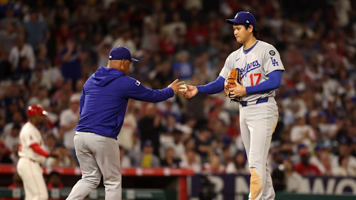 Aug 13, 2025; Anaheim, California, USA; Los Angeles Dodgers two-way player Shohei Ohtani (17) hands the ball to manager Dave Roberts (30, left) during the fifth inning against the Los Angeles Angels at Angel Stadium. Mandatory Credit: Kiyoshi Mio-Imagn Images Aug 13, 2025; Anaheim, California, USA; Los Angeles Dodgers two-way player Shohei Ohtani (17) hands the ball to manager Dave Roberts (30, left) during the fifth inning against the Los Angeles Angels at Angel Stadium. Mandatory Credit: Kiyoshi Mio-Imagn Images