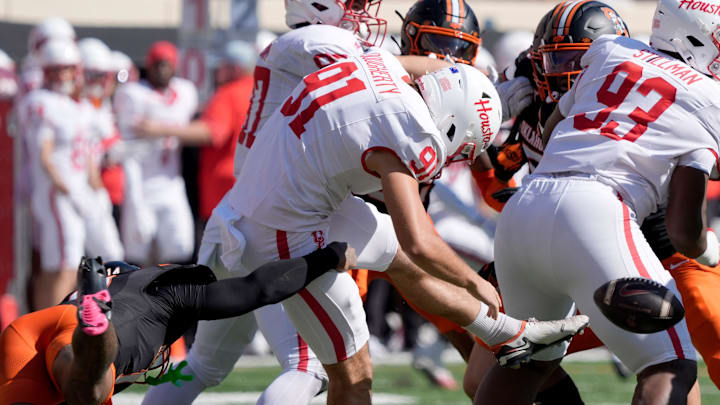 Oklahoma State Cowboys safety Landyn Cleveland (14) tries to tackle Houston Cougars punter Liam Dougherty (91) as he punts during a college football game between the Oklahoma State Cowboys (OSU) and the Houston Cougars at Boone Pickens Stadium in Stillwater, Okla., Saturday, Oct. 11, 2025. Oklahoma State Cowboys safety Landyn Cleveland (14) tries to tackle Houston Cougars punter Liam Dougherty (91) as he punts during a college football game between the Oklahoma State Cowboys (OSU) and the Houston Cougars at Boone Pickens Stadium in Stillwater, Okla., Saturday, Oct. 11, 2025.