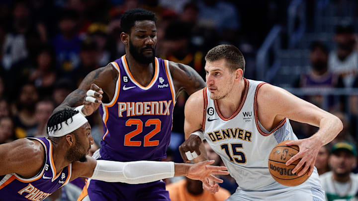May 9, 2023; Denver, Colorado, USA; Denver Nuggets center Nikola Jokic (15) controls the ball under pressure from Phoenix Suns center Deandre Ayton (22) and forward Josh Okogie (2) in the first quarter during game five of the 2023 NBA playoffs at Ball Arena. Mandatory Credit: Isaiah J. Downing-Imagn Images