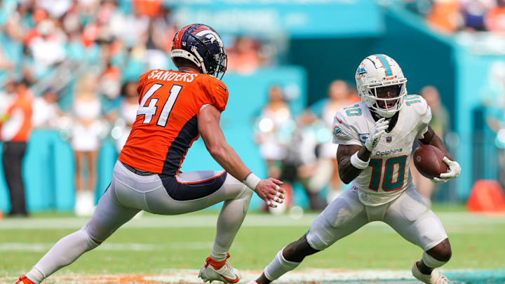 Sep 24, 2023; Miami Gardens, Florida, USA;  Miami Dolphins wide receiver Tyreek Hill (10) runs with the ball past Broncos linebacker Drew Sanders. 
