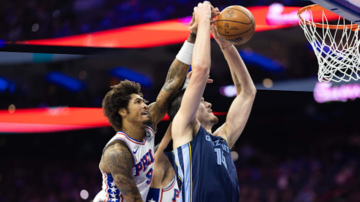 Philadelphia 76ers guard Kelly Oubre Jr. (9) blocks the drive of Memphis Grizzlies center Zach Edey (14) during the third quarter at Wells Fargo Center. Mandatory Credit: Bill Streicher-Imagn Images
