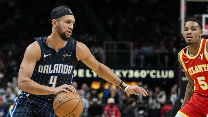 Feb 25, 2024; Atlanta, Georgia, USA; Orlando Magic guard Jalen Suggs (4) brings the ball past Atlanta Hawks guard Dejounte Murray (5) during the first half at State Farm Arena. Mandatory Credit: Dale Zanine-USA TODAY Sports