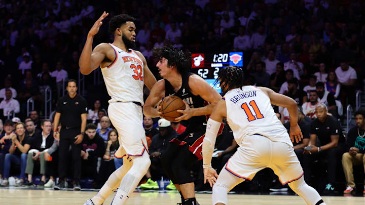 Oct 30, 2024; Miami, Florida, USA; Miami Heat guard Jaime Jaquez Jr. (11) protects the basketball against New York Knicks center Karl-Anthony Towns (32) during the second quarter at Kaseya Center. Mandatory Credit: Sam Navarro-Imagn Images