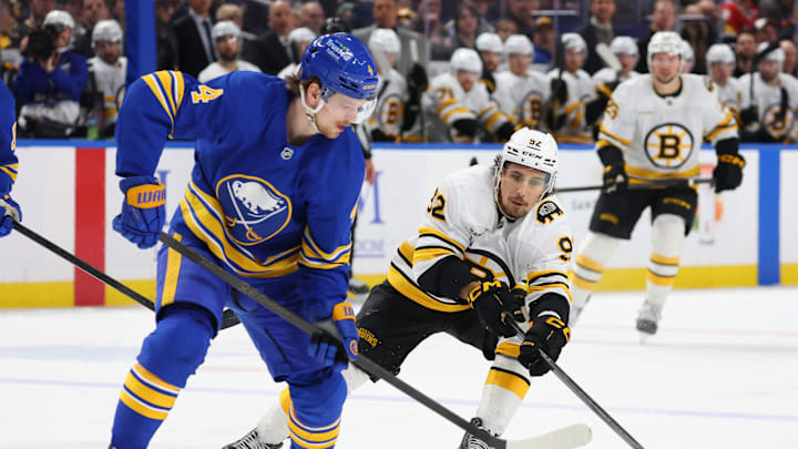 Mar 25, 2026; Buffalo, New York, USA;  Buffalo Sabres defenseman Bowen Byram (4) looks to control the puck as Boston Bruins center Marat Khusnutdinov (92) defends during the third period at KeyBank Center. Mandatory Credit: Timothy T. Ludwig-Imagn Images