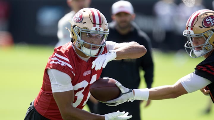 Jul 23, 2025; Santa Clara, CA, USA; San Francisco 49ers running back Isaac Guerendo (31) takes a handoff from quarterback Mac Jones (10) during the first day of training camp at SAP Performance Facility. Mandatory Credit: D. Ross Cameron-Imagn Images Jul 23, 2025; Santa Clara, CA, USA; San Francisco 49ers running back Isaac Guerendo (31) takes a handoff from quarterback Mac Jones (10) during the first day of training camp at SAP Performance Facility. Mandatory Credit: D. Ross Cameron-Imagn Images