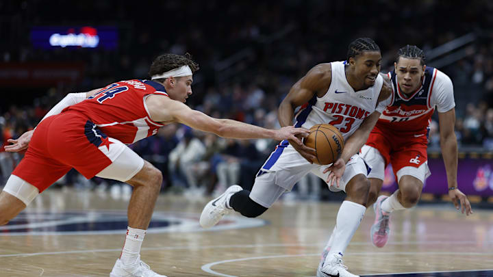 Nov 17, 2024; Washington, District of Columbia, USA; Detroit Pistons guard Jaden Ivey (23) drives to the basket as Washington Wizards forward Corey Kispert (24) and Wizards forward Kyshawn George (18) defend in the first half at Capital One Arena. Mandatory Credit: Geoff Burke-Imagn Images