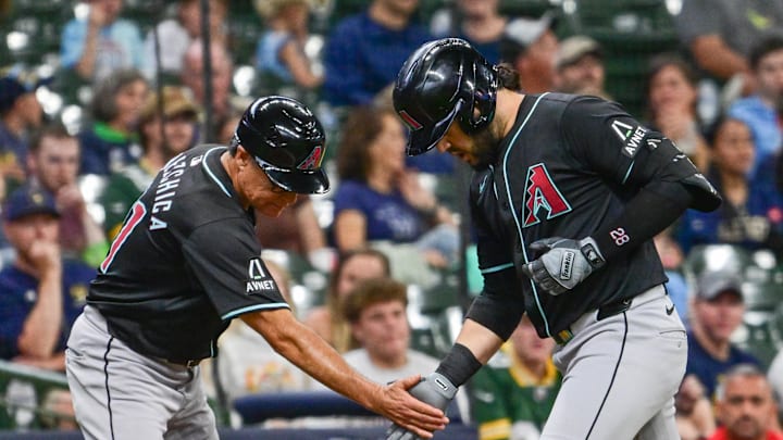 Sep 22, 2024; Milwaukee, Wisconsin, USA; Arizona Diamondbacks third baseman Eugenio Suarez (28) greets third base coach Tony Perezchica after hitting a solo home run in the third inning against the Milwaukee Brewers at American Family Field. Mandatory Credit: Benny Sieu-Imagn Images