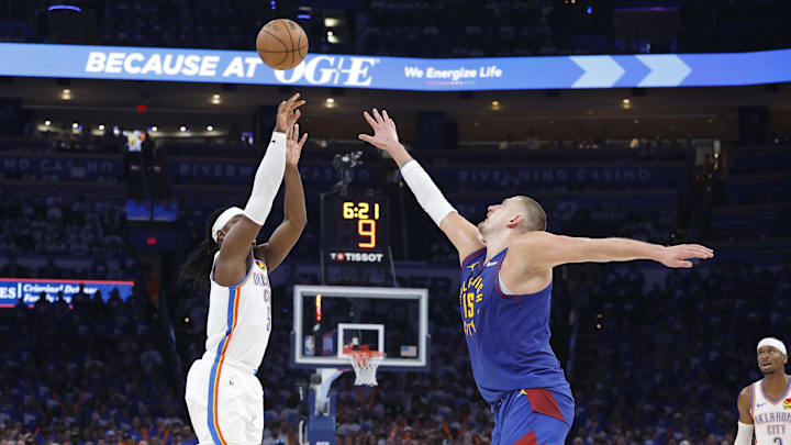 May 13, 2025; Oklahoma City, Oklahoma, USA; Oklahoma City Thunder guard Luguentz Dort (5) shoots a three point basket as Denver Nuggets center Nikola Jokic (15) defends during the second half of game five of the second round for the 2025 NBA Playoffs at Paycom Center. Mandatory Credit: Alonzo Adams-Imagn Images