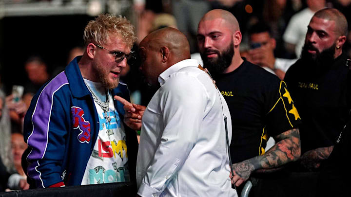 Apr 24, 2021; Jacksonville, Florida, USA; YouTube star Jake Paul is confronted by UFC ringside announcer Daniel Cormier before Anthony Smith (Red Gloves) fights Jimmy Crute (Blue Gloves) during UFC 261 at VyStar Veterans Memorial Arena. Mandatory Credit: Jasen Vinlove-Imagn Images