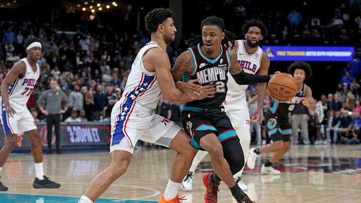 Dec 30, 2025; Memphis, Tennessee, USA; Memphis Grizzlies guard Ja Morant (12) drives to the basket as Philadelphia 76ers guard Quentin Grimes (5) defends during the fourth quarter at FedExForum. Mandatory Credit: Petre Thomas-Imagn Images