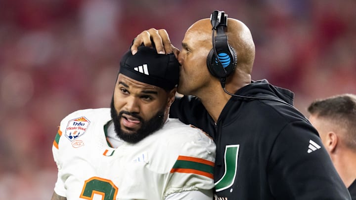 Jan 8, 2026; Glendale, AZ, USA; Miami Hurricanes defensive line coach Jason Taylor kisses the head of defensive lineman Akheem Mesidor (3) after suffering an injury against the Mississippi Rebels during the 2026 Fiesta Bowl and semifinal game of the College Football Playoff at State Farm Stadium. Mandatory Credit: Mark J. Rebilas-Imagn Images